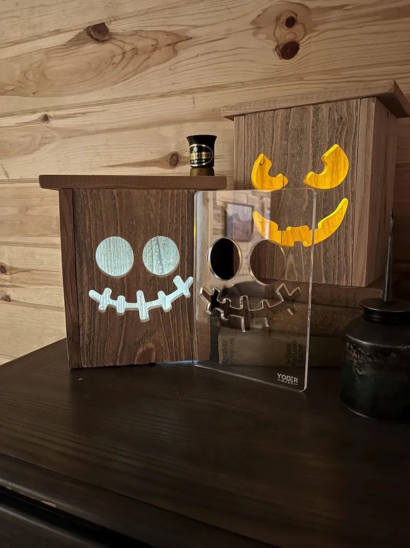 A clear image of the acrylic pumpkin face template next to a wooden box that the template has been used on.